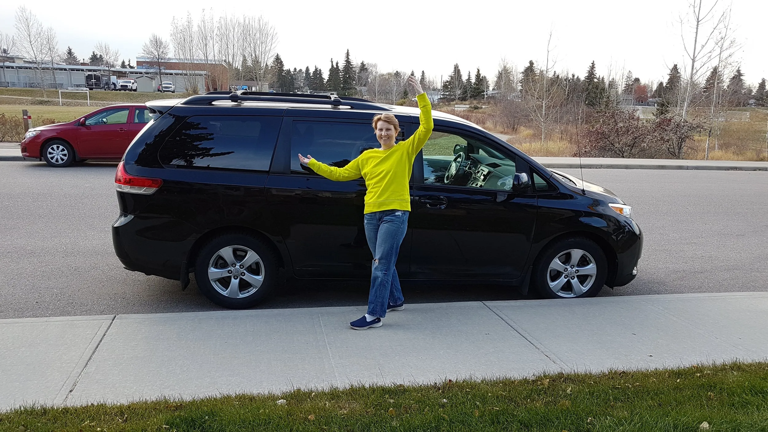 Charlene happily standing next to her work van